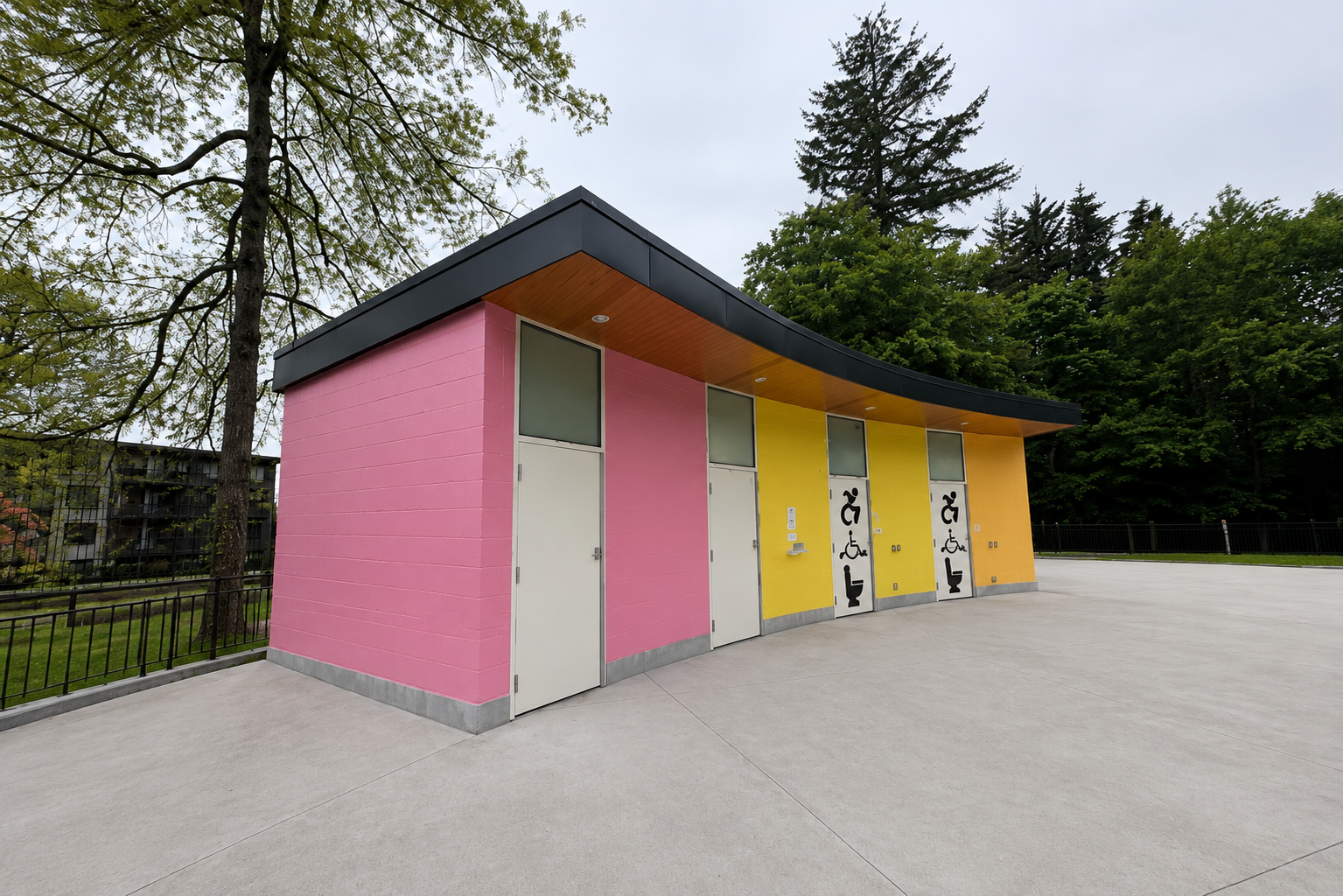Colourful public washroom building with pink and yellow cladding